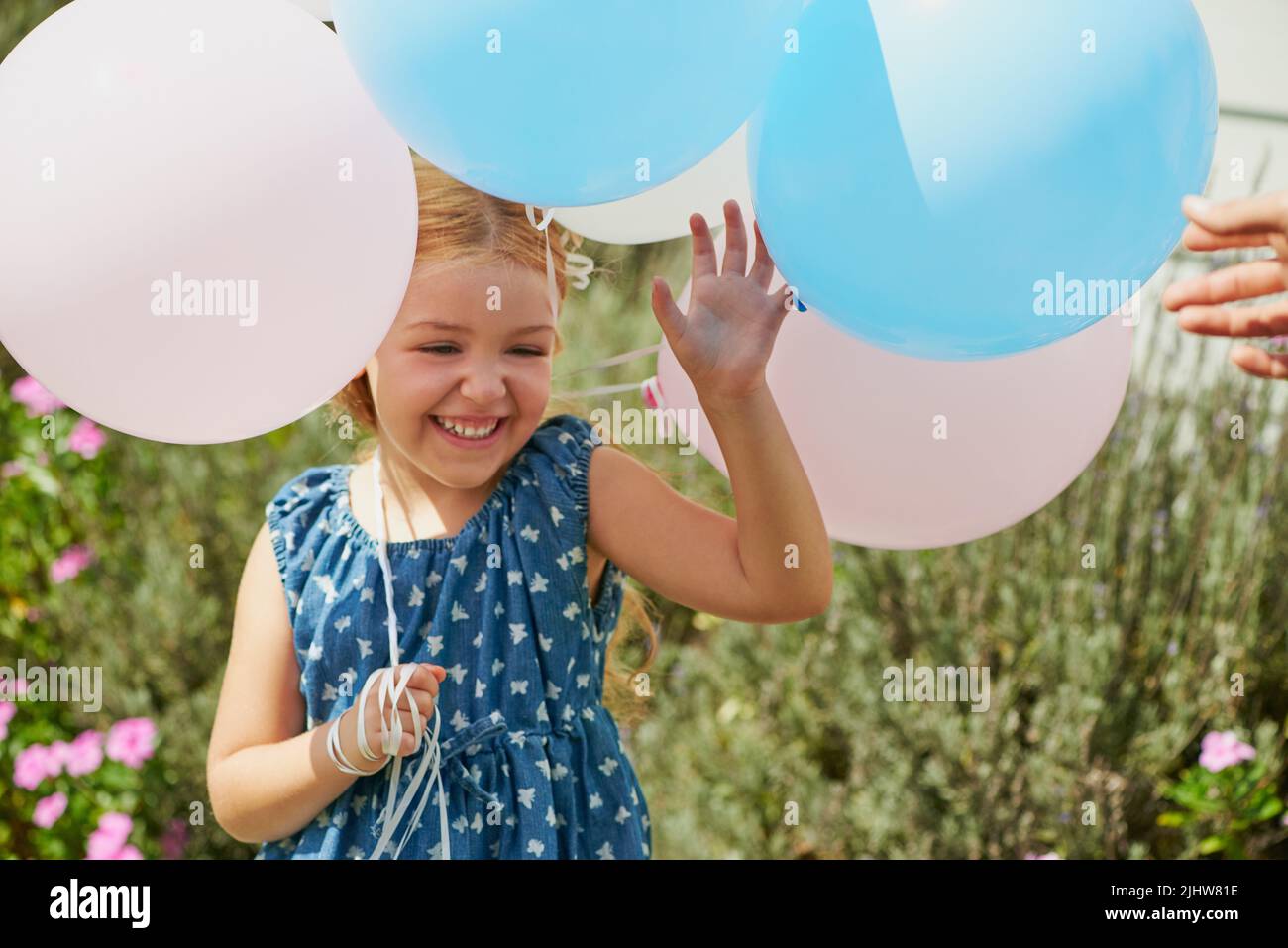 Luftballons sind zu jeder Gelegenheit groß. Ein glückliches kleines Mädchen, das mit Luftballons zu Hause spielt. Stockfoto