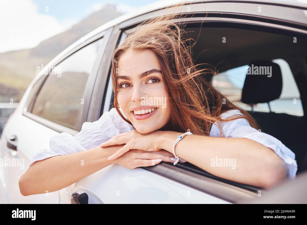 Was gibt es Schöneres, als zu reisen. Eine schöne junge Frau genießt eine abenteuerliche Fahrt im Auto. Stockfoto