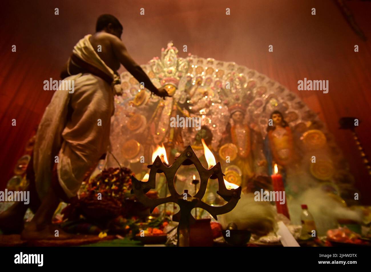 Howrah, Westbengalen, Indien - 13.. Oktober 2021 : die Göttin Durga wird von einem hinduistischen Priester mit heiliger Panchapradip, im Untergrund, während des Aschtams verehrt Stockfoto