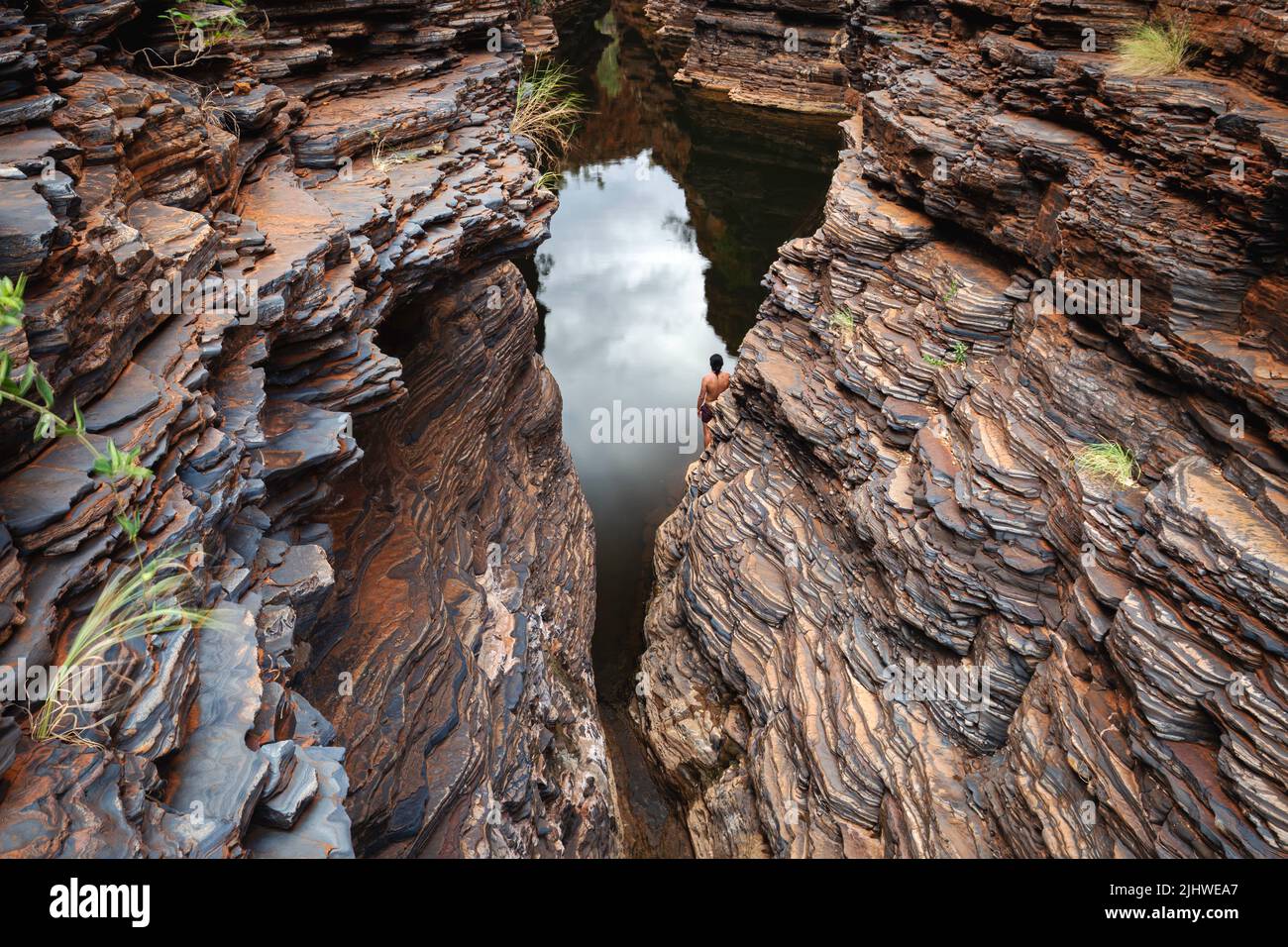 Ein Mann, der in einer Schlucht, im Karijini National Park, Westaustralien, steht Stockfoto