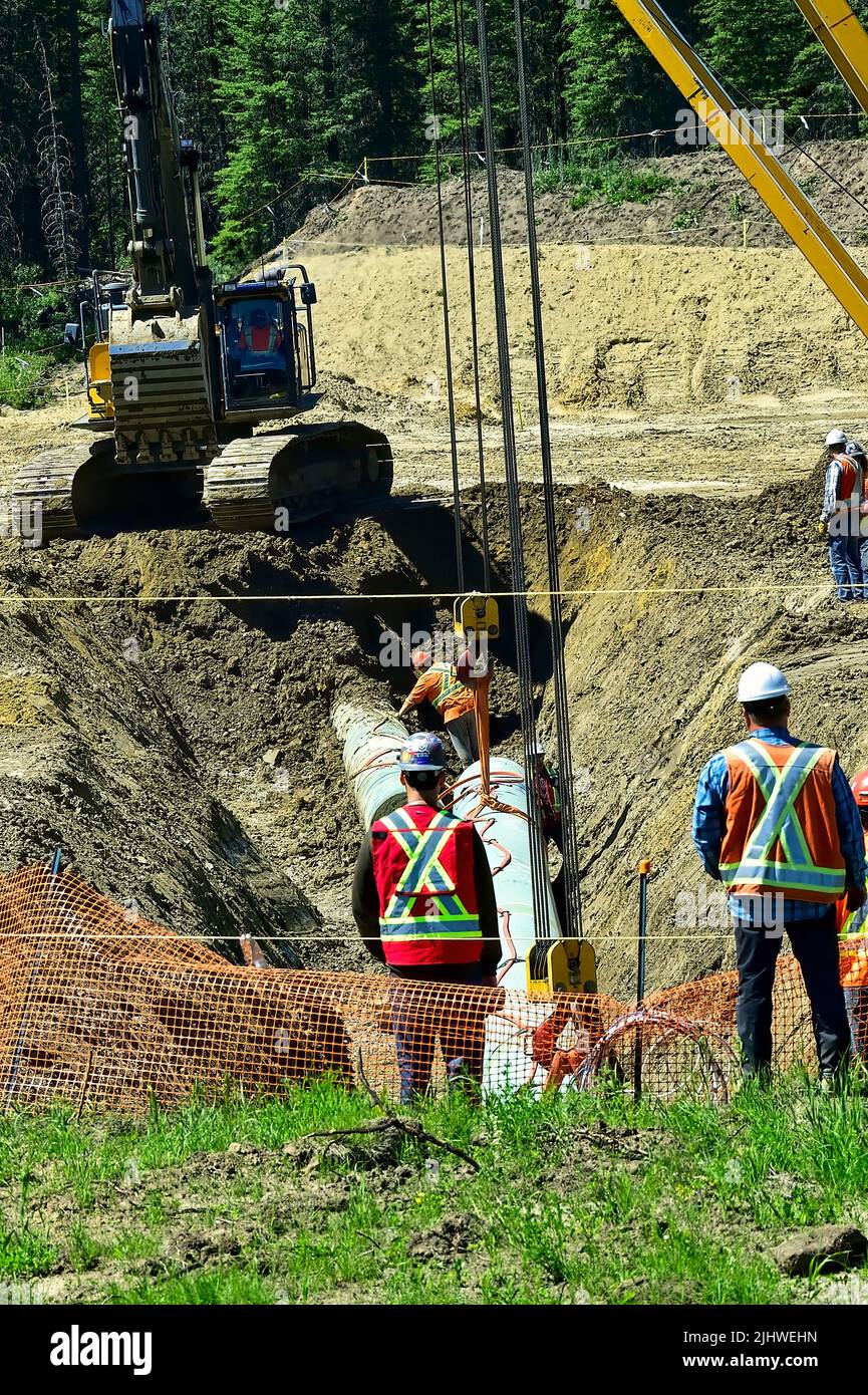 Ein vertikales Bild der Arbeiter, die die Trans Mountain Pipeline im ländlichen Alberta in Kanada verlegen Stockfoto