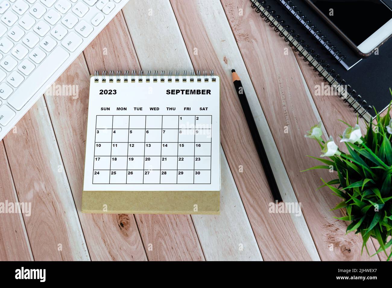 Weißer Tischkalender September 2023 auf Holzschreibtisch. Direkt darüber. Flach liegend. Stockfoto