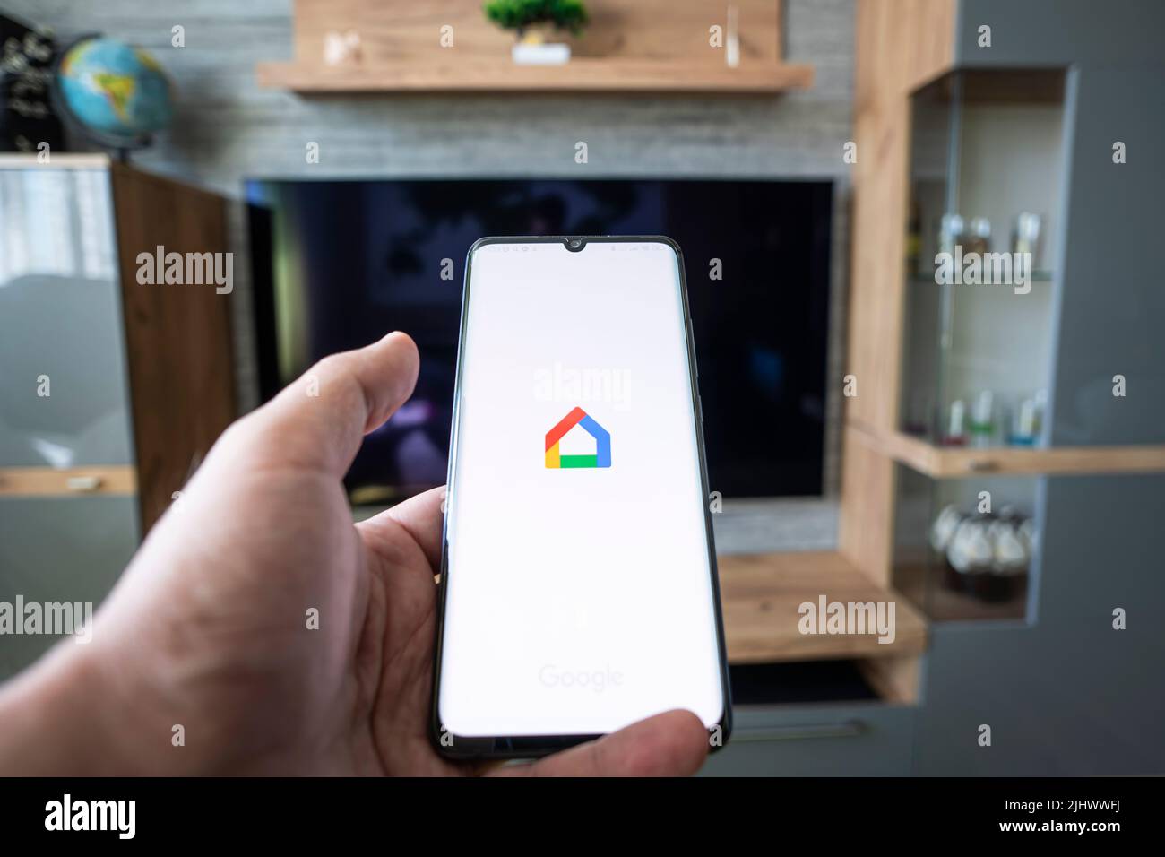 Barnaul. Russland. 21. Juni 2022: Google Home Smart-Steuerung des Fernsehgeräts in der Wohnung über die App auf dem Smartphone. Stockfoto