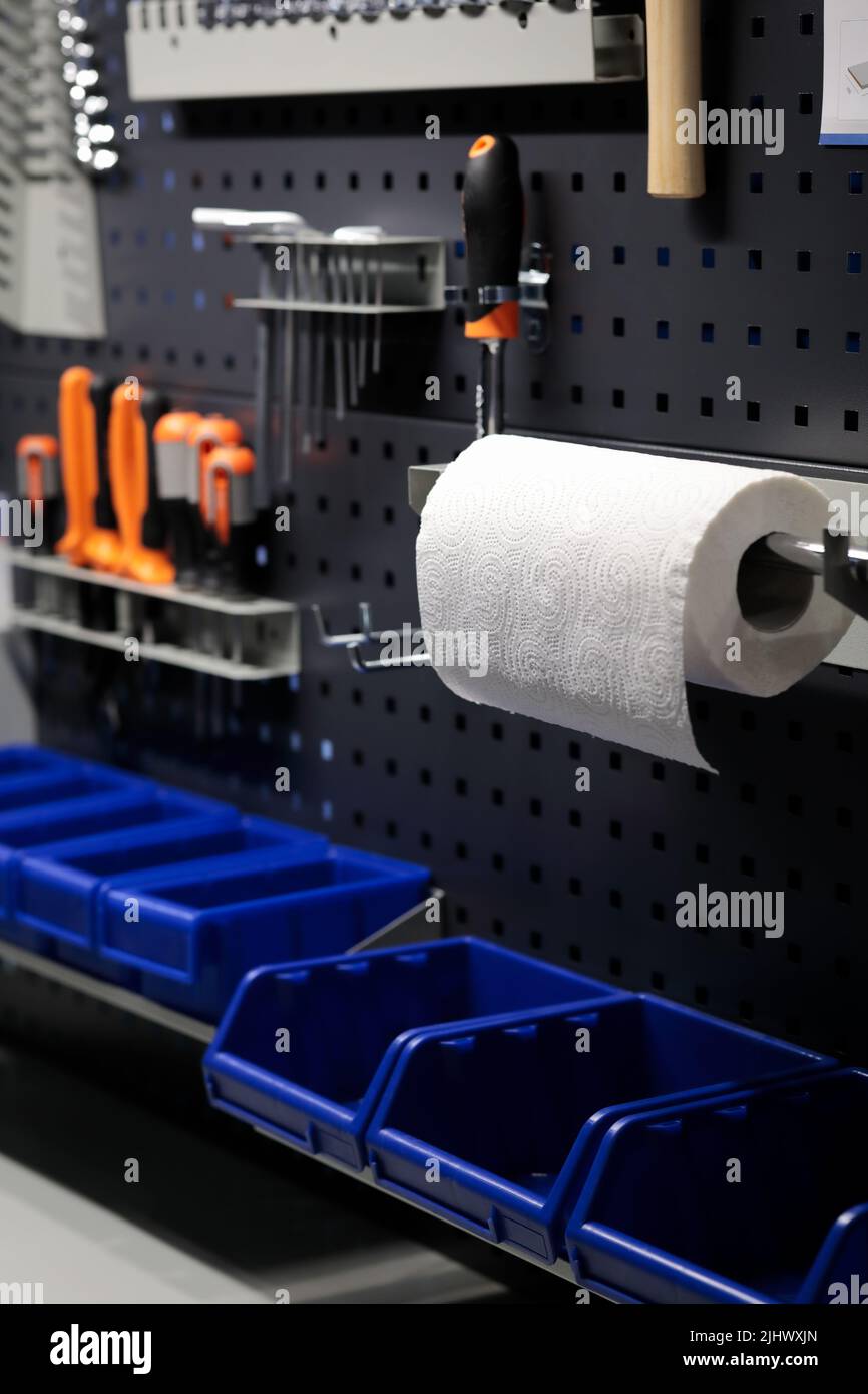Werkstattinnenraum mit Metall-Pegboard-Paneelen. Workshop mit Werkzeugen, die an einer Wand hängen. Selektiver Fokus. Stockfoto