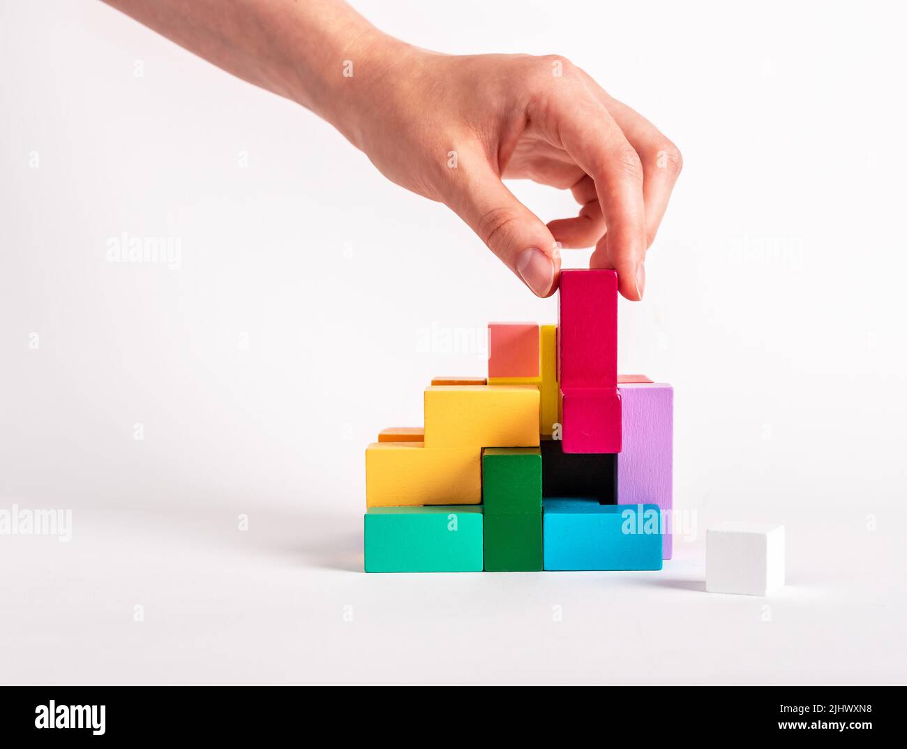 Frau löst logische Rätsel. Konstruktion, Montagekonzept. Entwicklung des analytischen Denkens. Holzspiel für Kinder und Erwachsene aus verschiedenen geometrischen Formen. Hochwertige Fotos Stockfoto