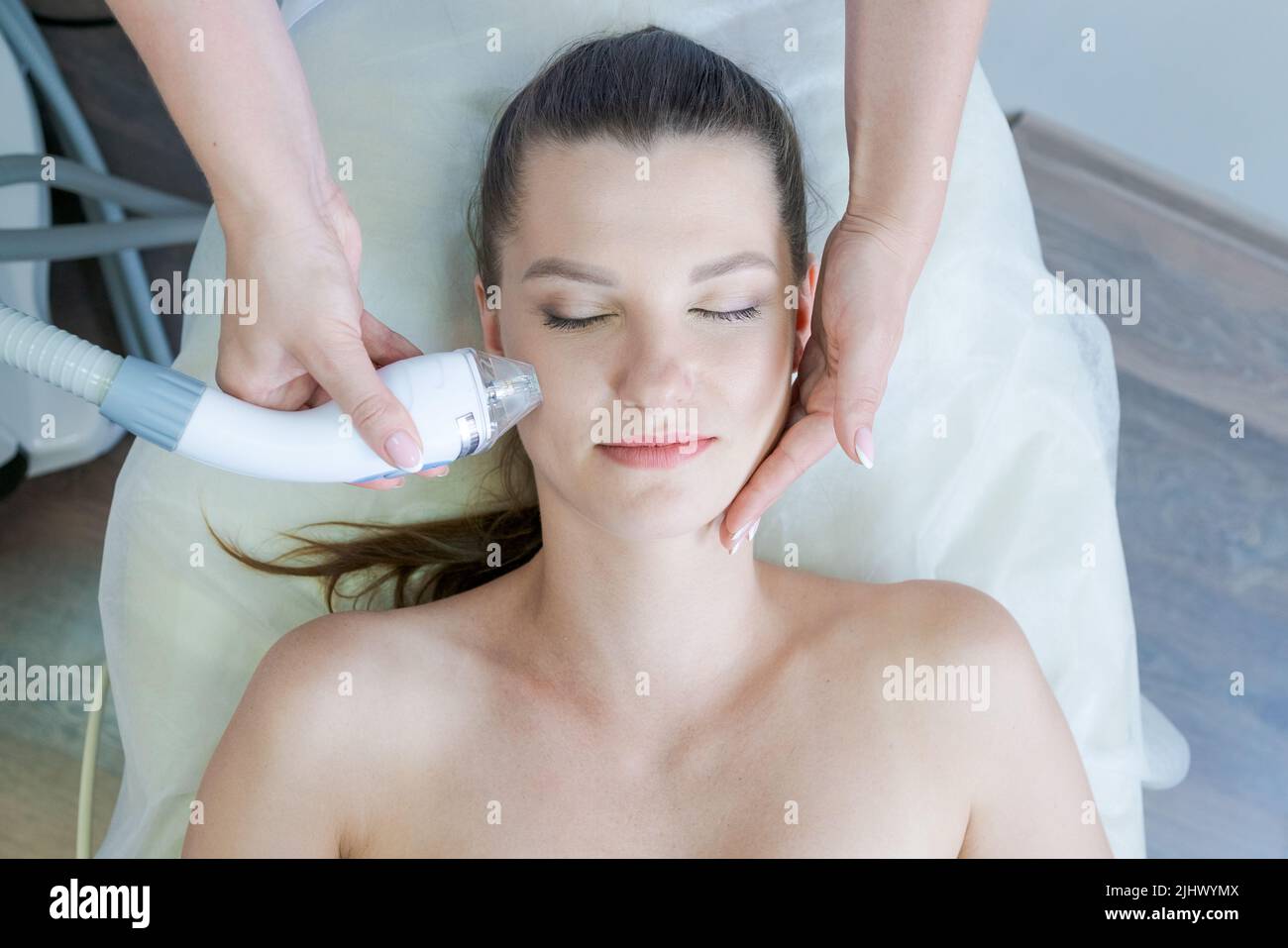 Spa-Verfahren für Frauen ansehen. Elektrische Stimulation Gesichtshautpflege. Mikrostrom-Hubfläche. Schönheitsbehandlungen im Spa. Verjüngung nicht-chirurgische Behandlung im Innenraum Stockfoto