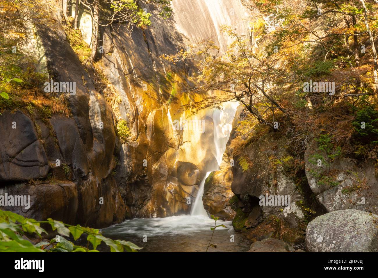 Wasserfall im Shosenkyo-Tal bei Herbstlaub Stockfoto