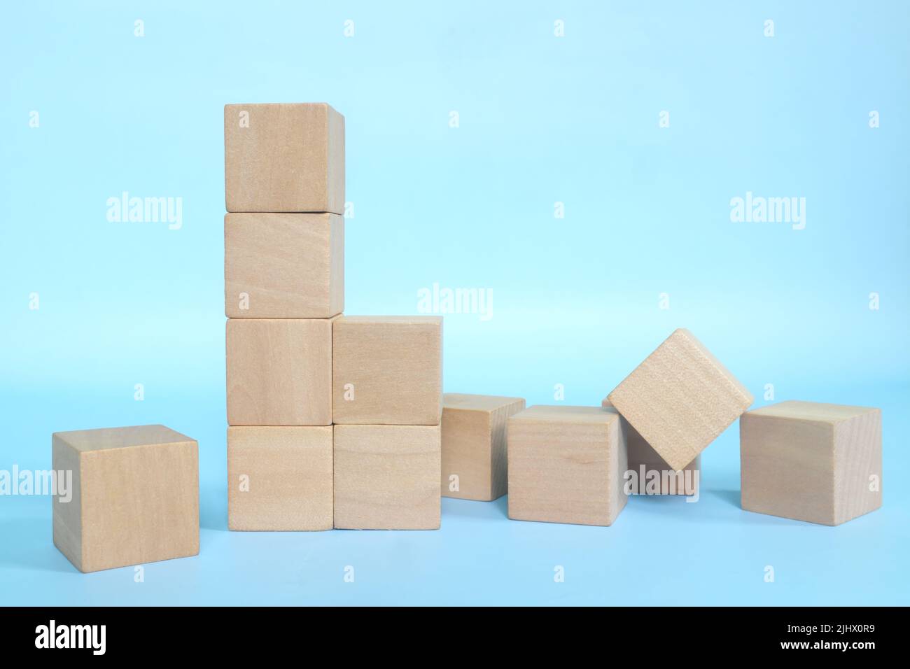 Eingestürzte Holzbausteine auf blauem Hintergrund. Schwache Grundlage und gebaut konzeptuell. Stockfoto