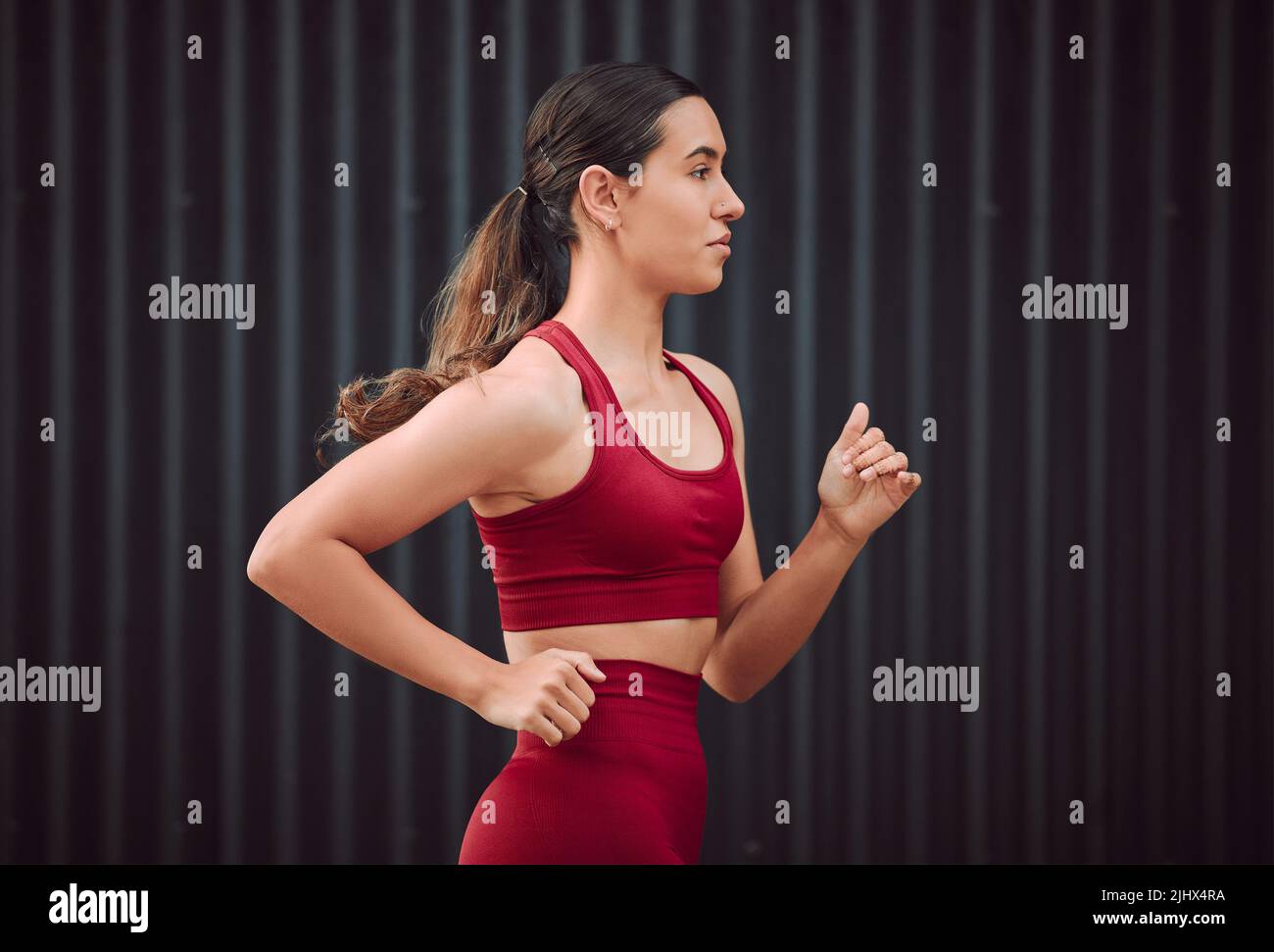 Eine attraktive junge Sportlerin, die im Freien läuft. Stockfoto