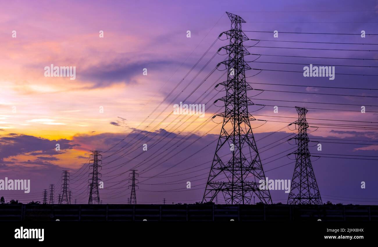 Silhouette eines Hochspannungstürms mit den Wolken bei Sonnenuntergang auf einem Hintergrund Stockfoto