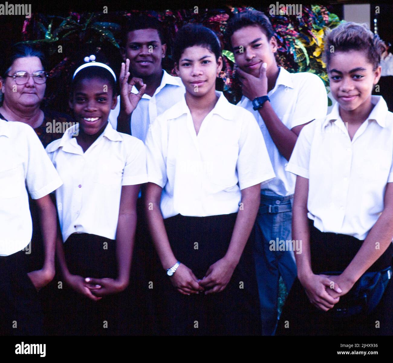 Gruppe von Jugendlichen High School Studenten mit ihrem Lehrer, Cayman Brac, Cayman Islands, West Indies 1990 Stockfoto