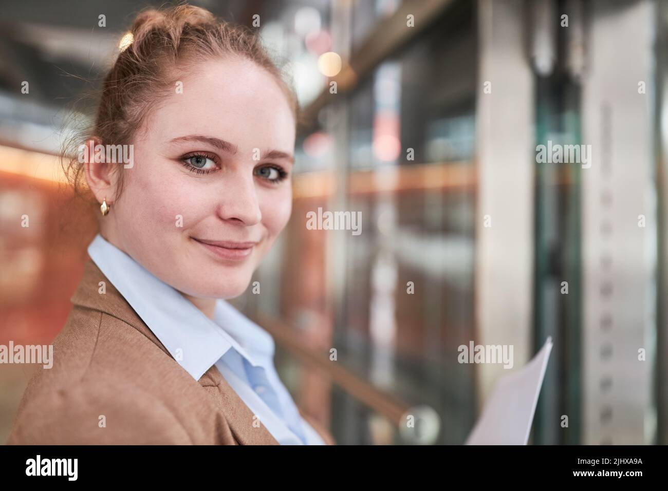Lächelnde junge Frau als Auszubildende oder Studentin Stockfoto