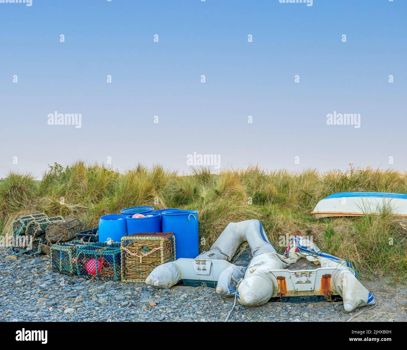 fishermans Hummertöpfe Krabbenkisten blaue Fässer und entlüpfte Dingies in Cardigan West wales UK Stockfoto