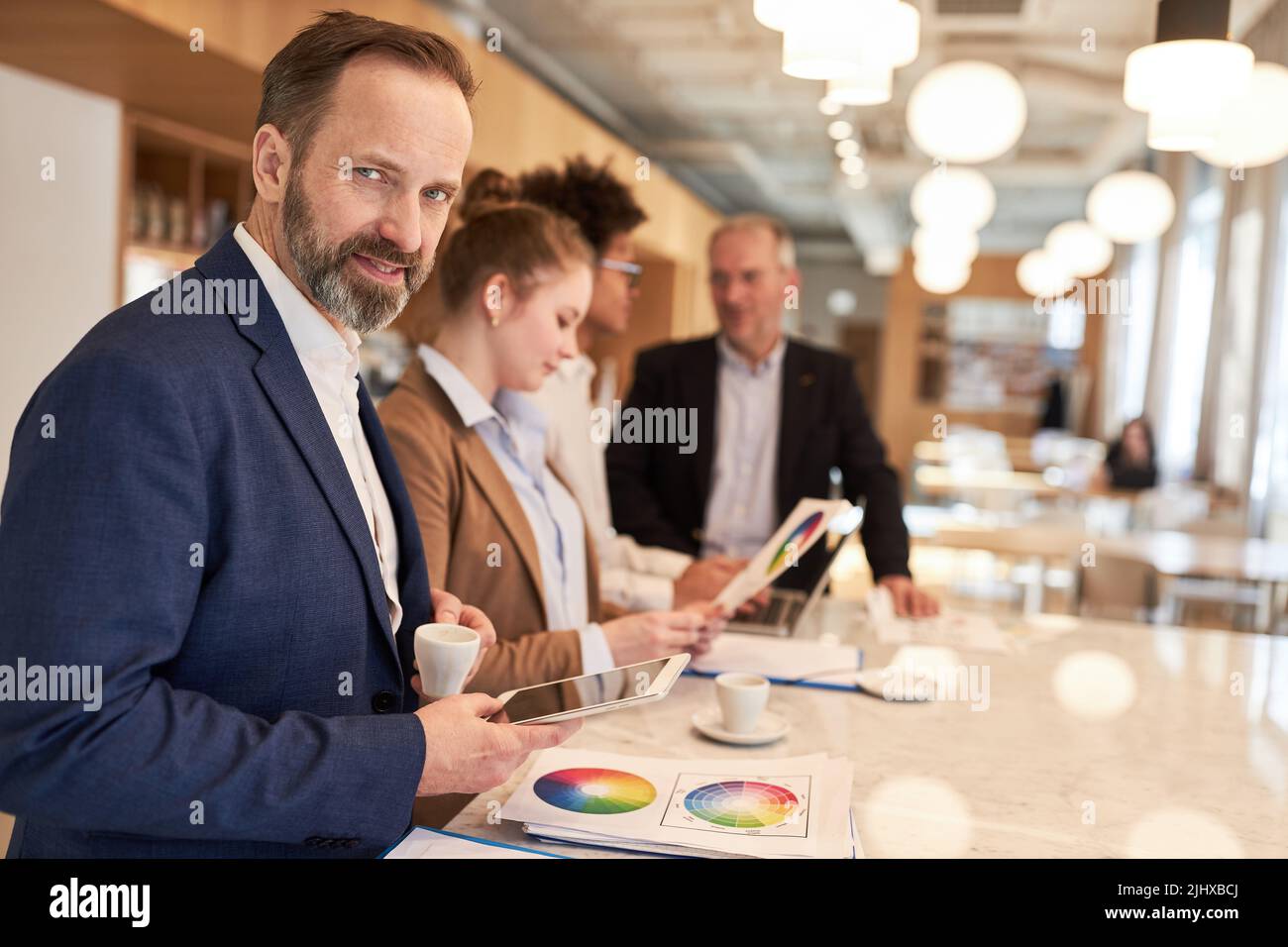 Erfolgreicher Manager als Leiter einer Werbeagentur in einem kreativen Workshop mit einem Team Stockfoto