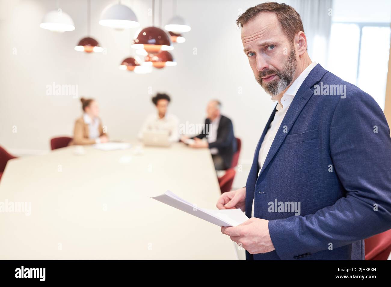 Geschäftsmann als skeptischer Berater mit Geschäftspapieren in der Besprechung Stockfoto