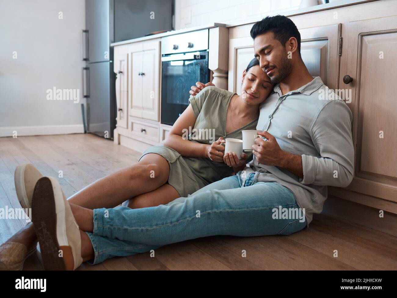 Du bist mein Zufluchtsort während der Stürme des Lebens. Ein junges Paar, das zu Hause zusammen eine Tasse Kaffee trinkt. Stockfoto