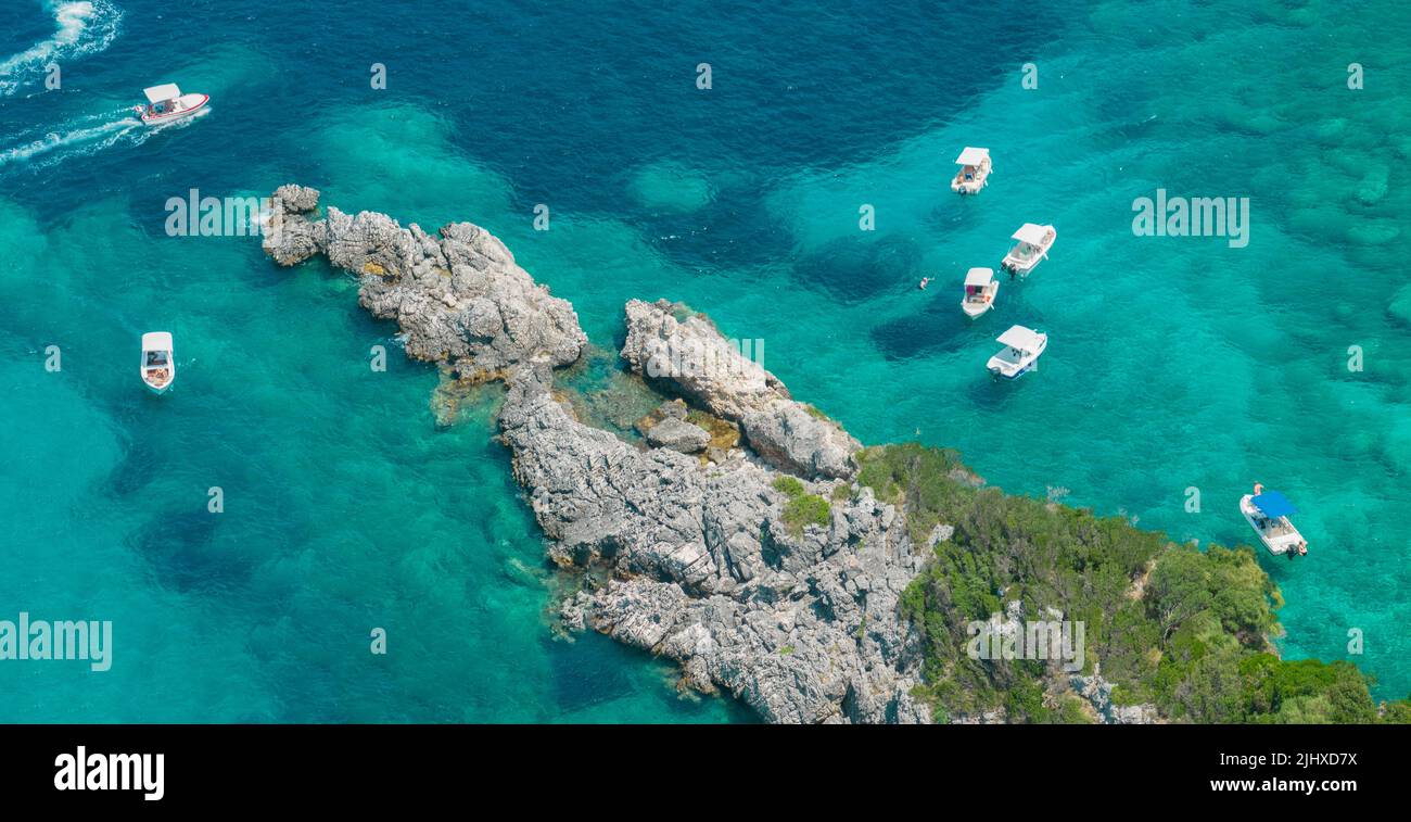 Luftaufnahme der Felsen zwischen dem Strand von Klimatia Beach und Limni Beach auf der Insel Korfu. Küste. Verankerte Boote, Badegäste. Griechenland Stockfoto