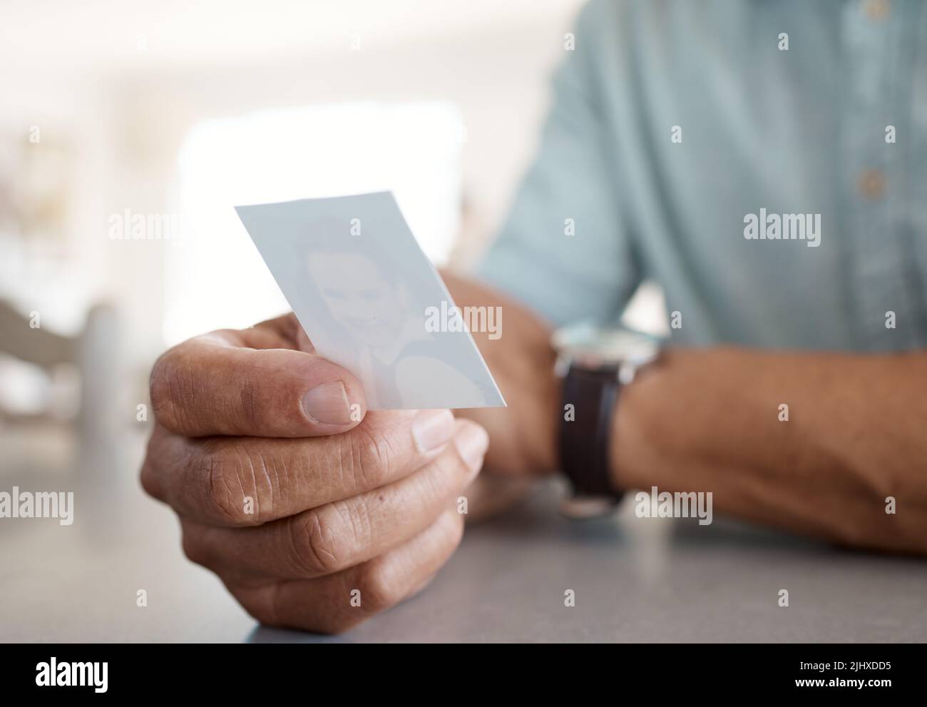 Die Erinnerungen sterben nie. Eine unkenntliche Person, die ein Foto zu Hause hält. Stockfoto