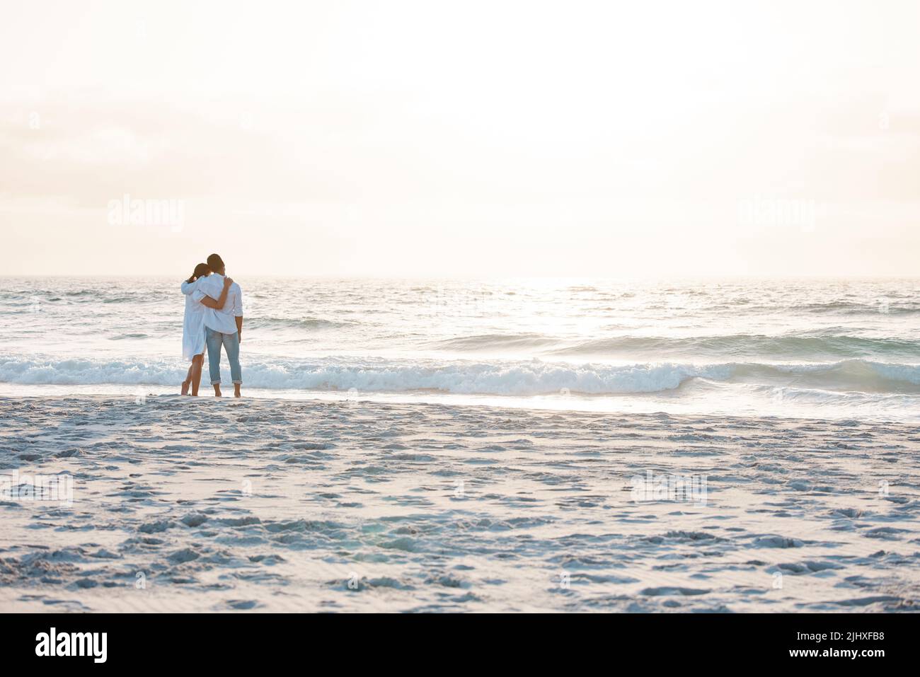Zugehörigkeit und Fürsorge verankern unseren Sinn für Platz im Universum. Ein junges Paar verbringt Zeit zusammen am Strand. Stockfoto