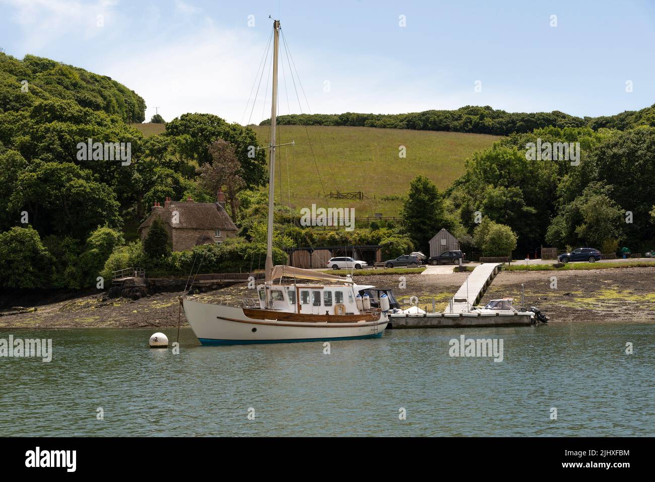 Falmouth Cornwall, England, Großbritannien. 2022. Reetgedeckte Hütte und Liegeplätze am Ufer des Flusses Fal in der Nähe von Falmouth, Cornwall, Großbritannien Stockfoto