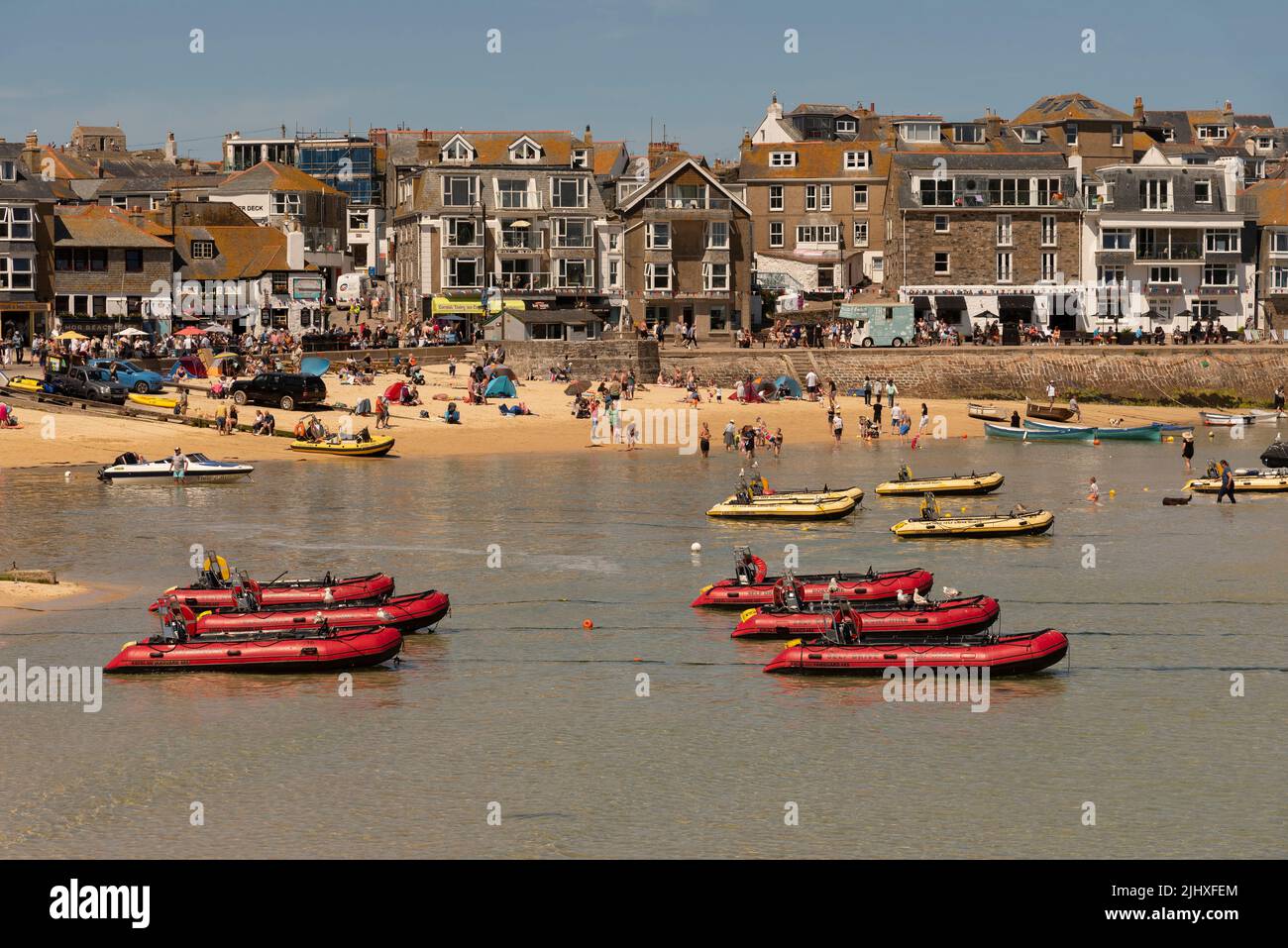 St Ives, Cornwall, England, Großbritannien. 2022. St Ives beliebter Badeort in Cornwall. Fahren Sie selbst rote aufblasbare Boote in flachem Wasser. Stockfoto