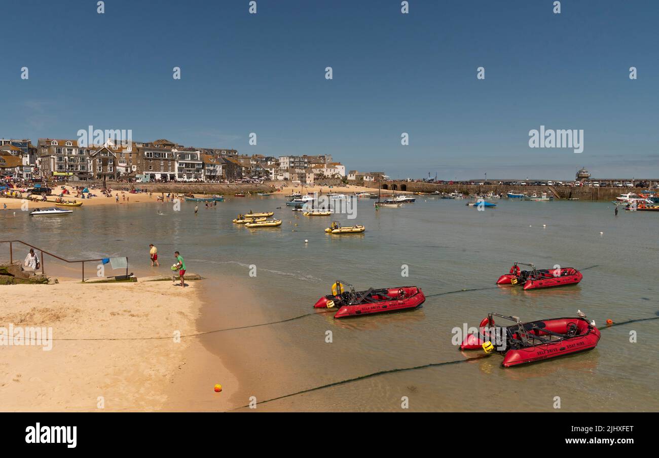 St Ives, Cornwall, England, Großbritannien. 2022. St Ives beliebter Badeort in Cornwall. Fahren Sie selbst rote aufblasbare Boote in flachem Wasser. Stockfoto