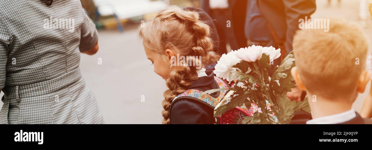 Zurück zur Schule. Kleine glückliche Kind Schüler Schülerin acht Jahre alt in Mode-Uniform mit Rucksack und Frisur voluminösen Zopf bereit zu secon Stockfoto