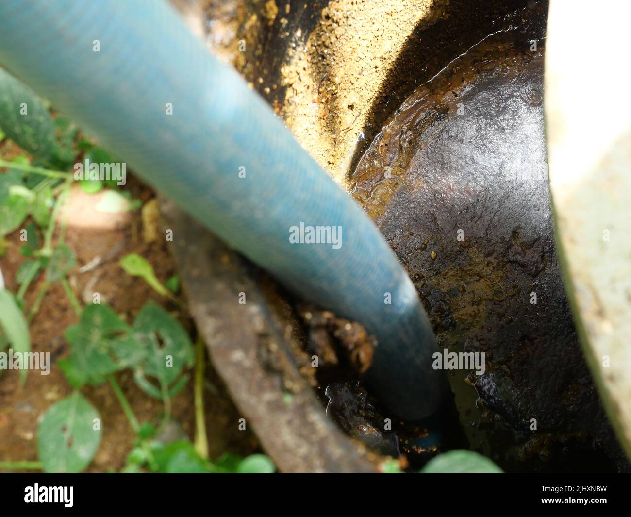 Die Entfernung von Klärschlamm und die Reinigung mit Vakuumrohr in Abfluss und Beton septischen Tank der Toilette, Abwasserbehandlungssystem des Hauses Stockfoto