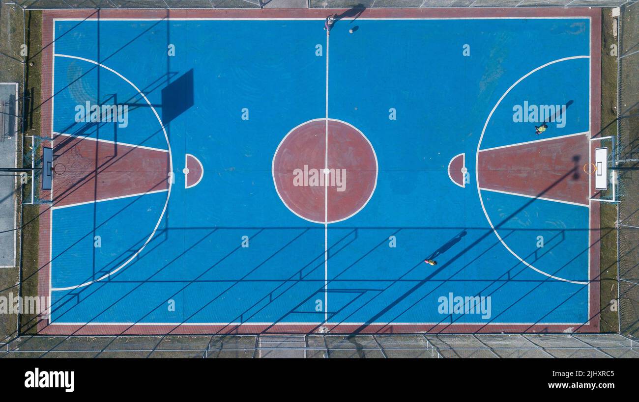 Außensportrahmen in roten und blauen Farben, Draufsicht mit Drohne, von verschiedenen Sportarten, einschließlich Basketball, Volleyball und Hallenfußball. Stockfoto