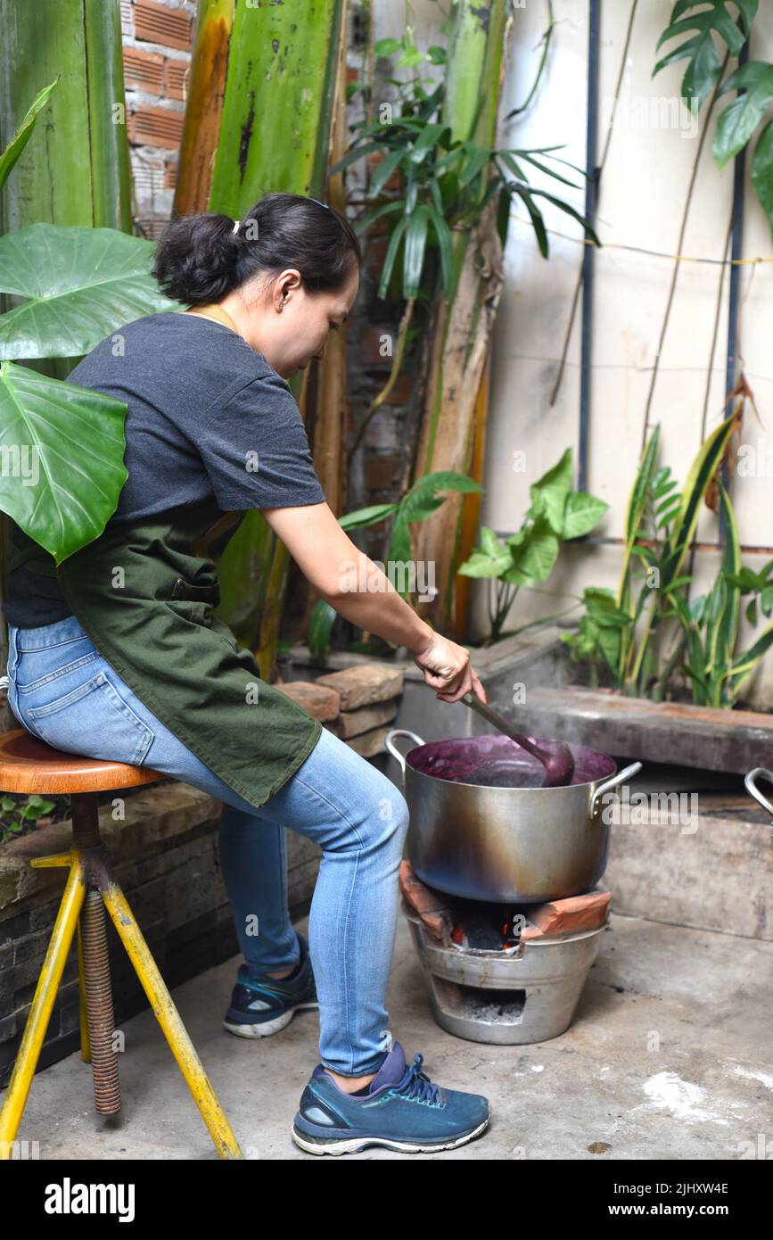 Junge Vietnamesin kocht eine Maulbeermarmelade in einem großen Topf Stockfoto
