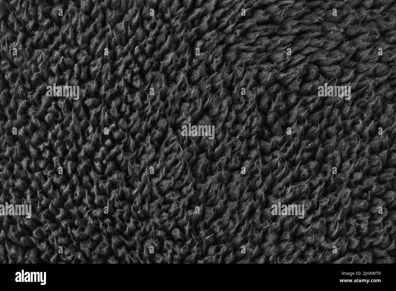 Kunstpelz schwarze Wolle abstraktes Muster Natur Haut weich warm flauschig Hintergrund dunkel künstliche Textur. Stockfoto