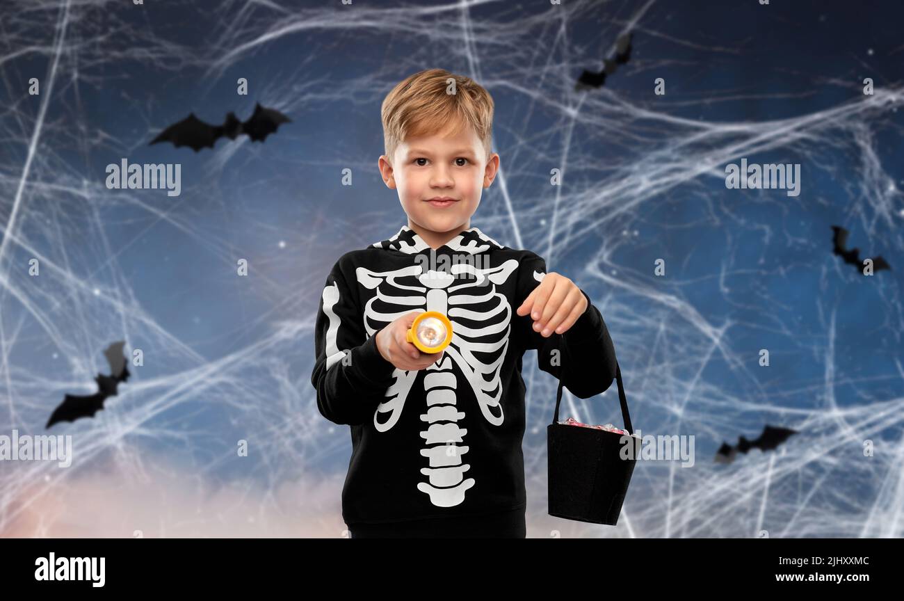 Junge mit Süßigkeiten und Taschenlampe an halloween Stockfoto