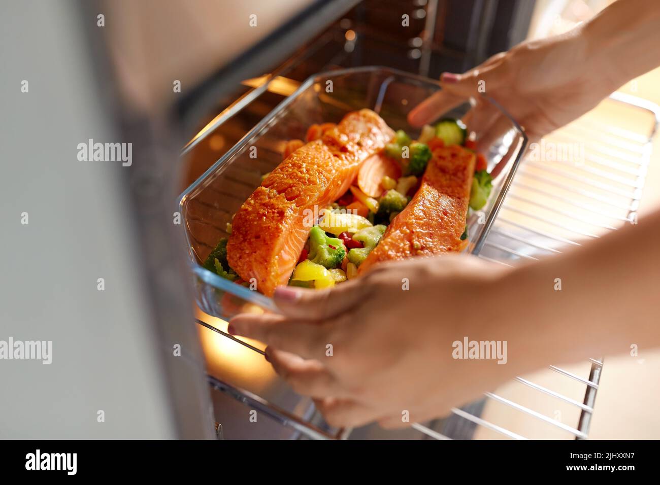 Frau, die in der heimischen Küche im Ofen kocht Stockfoto