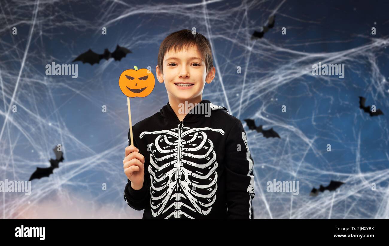 Junge im halloween Kostüm aus Skelett mit Kürbis Stockfoto