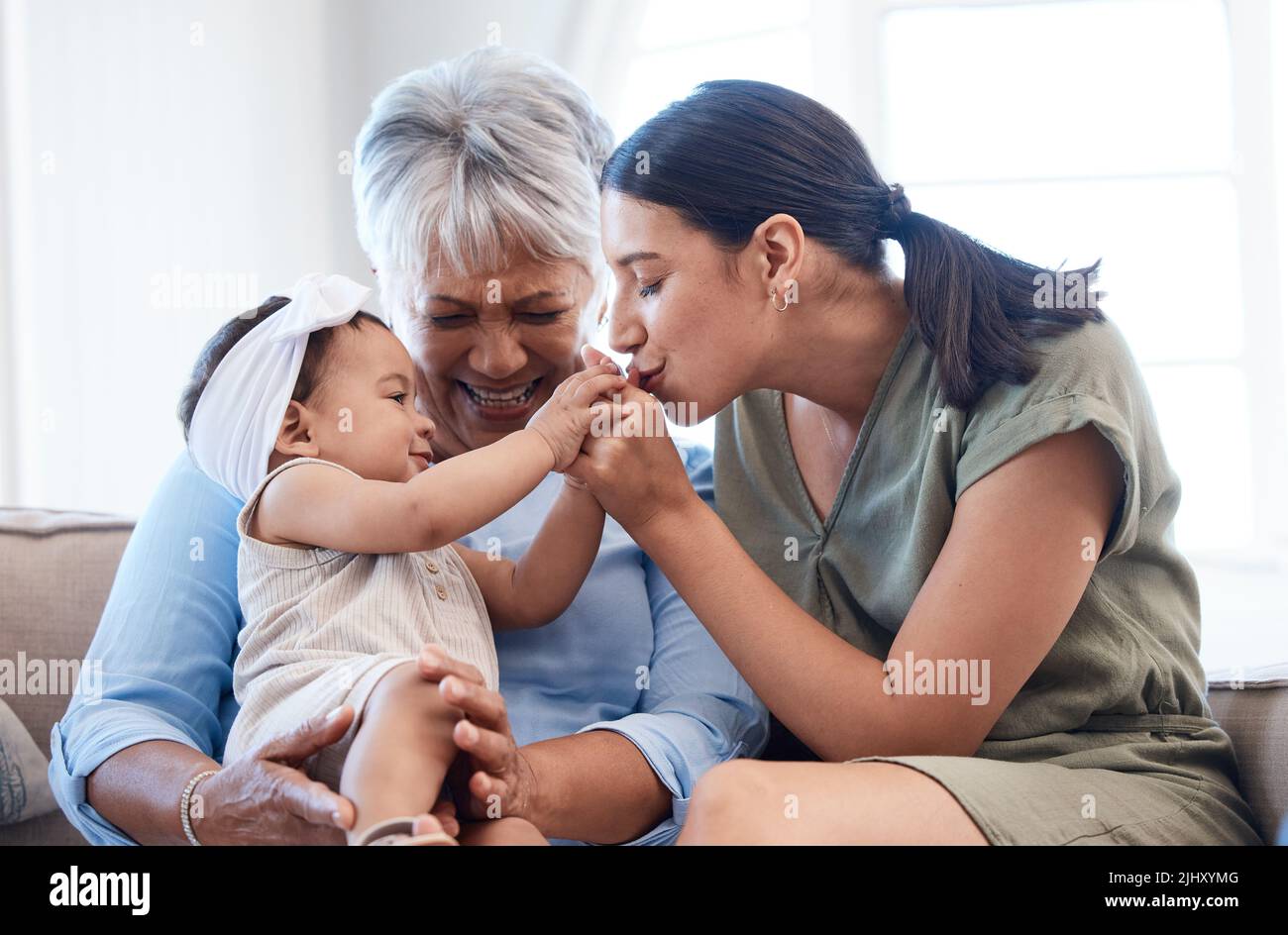 Glück beginnt mit glücklichen Frauen. Eine reife Frau, die sich mit ihrer Tochter und Enkelin auf dem Sofa verklebt. Stockfoto