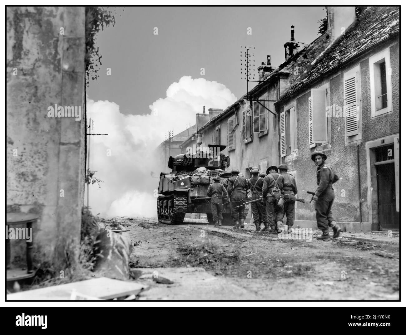 D-DAY WW2 Kanadische Armee Vormarsch durch die Ruinen von Falaise Normandie 1944 nach D-Day alliierten Invasion 6. 1944. Juni Falaise wurde von den Alliierten als eine Stadt von ausreichender Bedeutung, um verdienen ausgelöscht. Sie führte über den Weg nach Caen, einem D-Day-Ziel. Hier ebnet ein kanadischer Panzer mit Granatfeuer einen Weg durch. Stockfoto