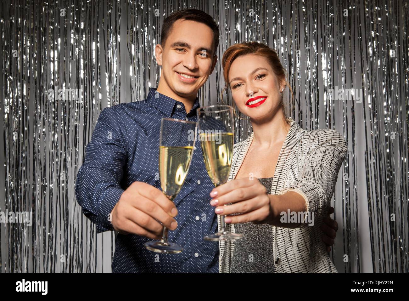 Glückliches Paar, das auf der Party Champagner-Gläser toasting Stockfoto
