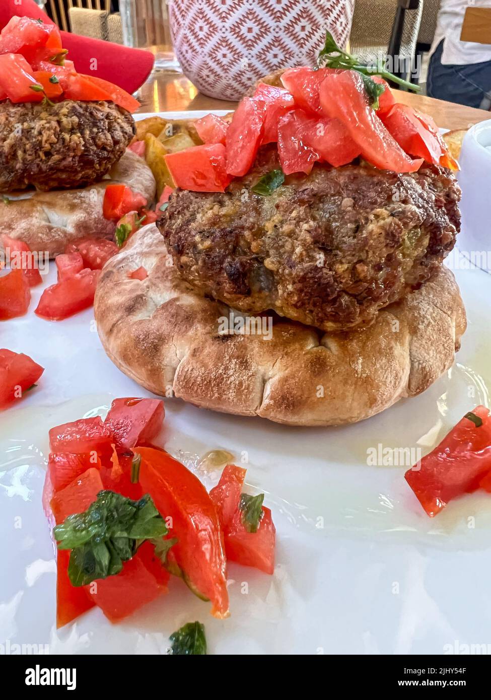 Fleischbällchen, Nahaufnahme Seitenansicht leckere Fleischbällchen serviert auf Pita-Brot mit Tomatensalat auf dem Teller zum Mittag- oder Abendessen. Fast-Food-Konzept Foto mit Sel Stockfoto