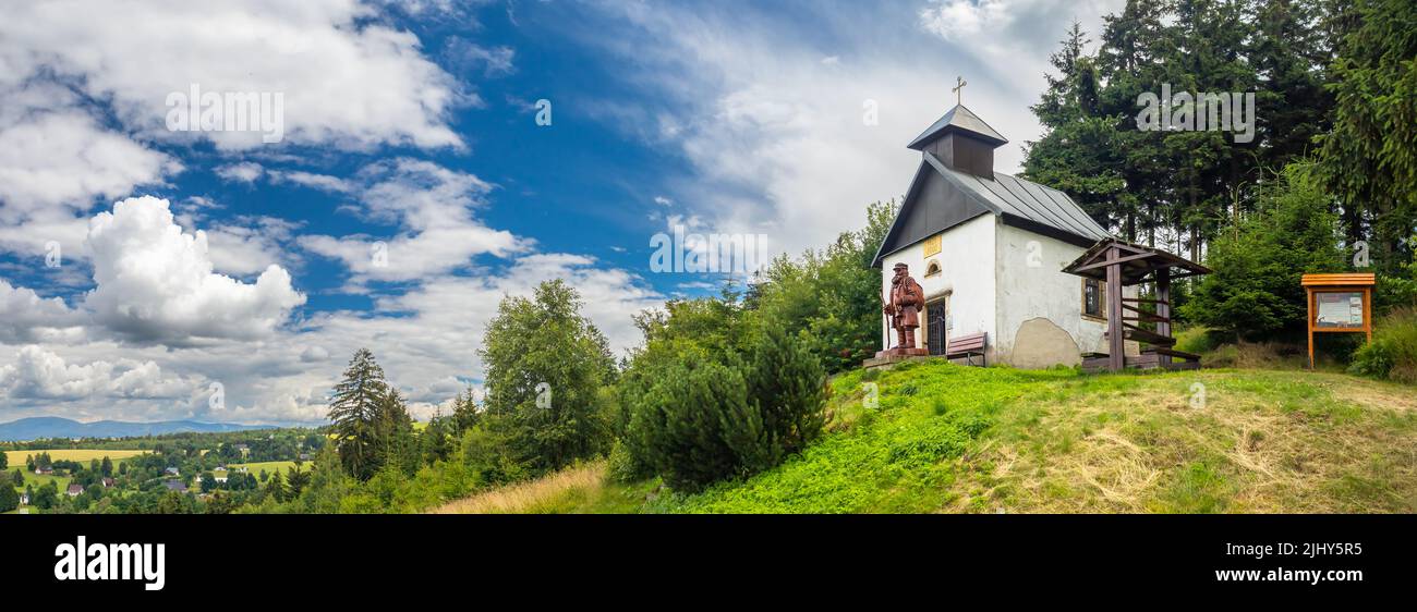 Kapelle der Himmelfahrt der Jungfrau Maria mit der Statue eines Pilgers auf dem Adam-Hügel in der Nähe von Ceske Petrovice, Tschechische republik Stockfoto