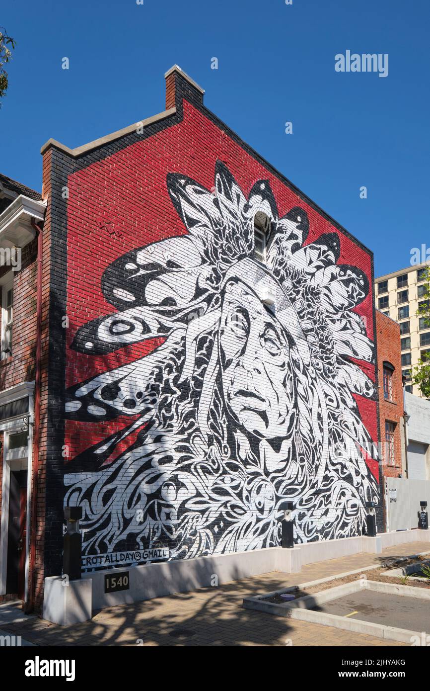 Ein riesiges Wandbild auf einer roten Ziegelwand, das ein Porträt eines legendären Indianerhäuptlings zeigt. Im Chinatown-Viertel der Innenstadt von Oakland, Kalifornien. Stockfoto