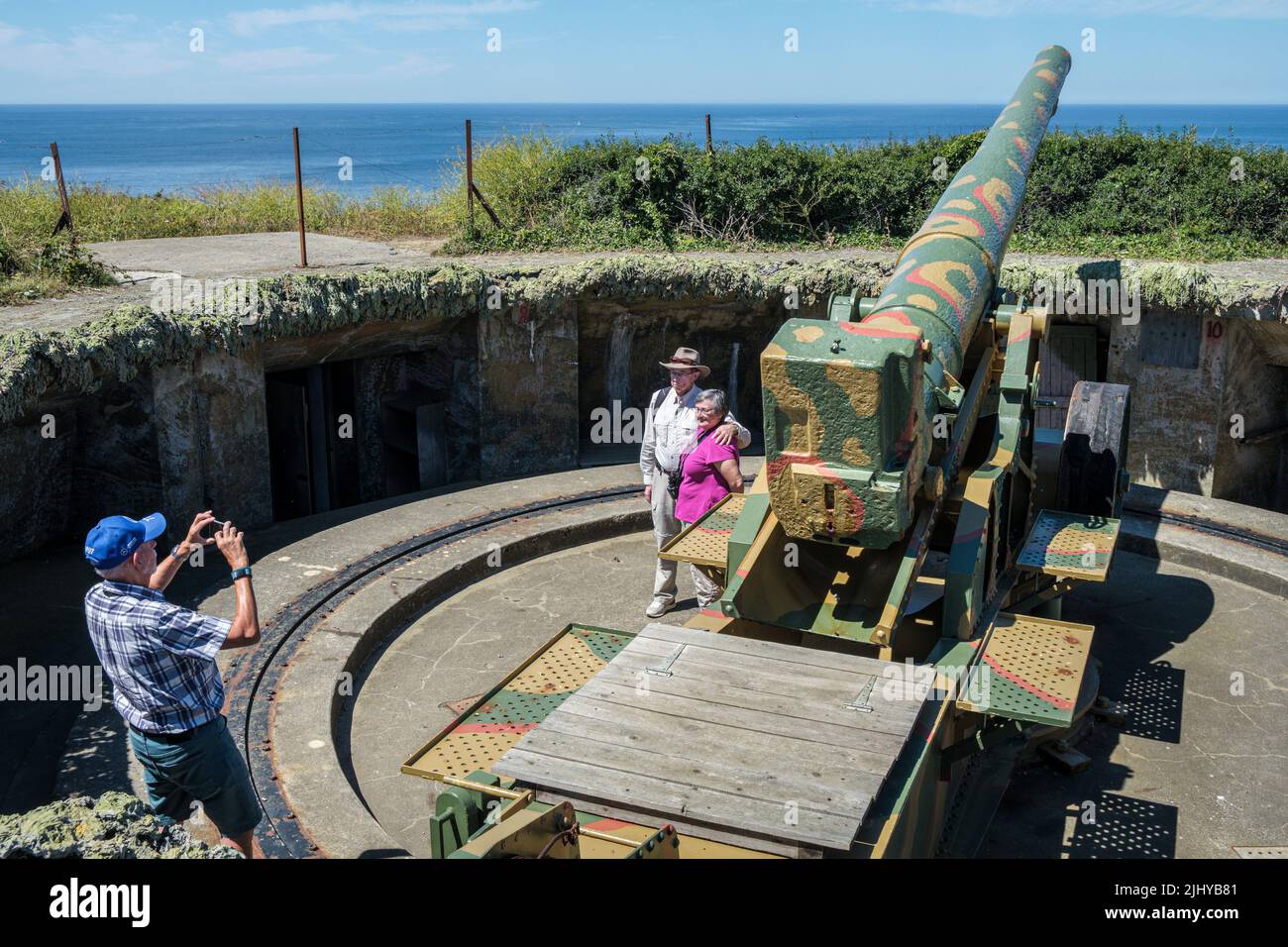 Amerikanische Touristen, die ihr Foto von der deutschen Waffe aus dem Zweiten Weltkrieg in der Batterie Generaloberst Dollman, Pleinmont, Guernsey, machen lassen Stockfoto