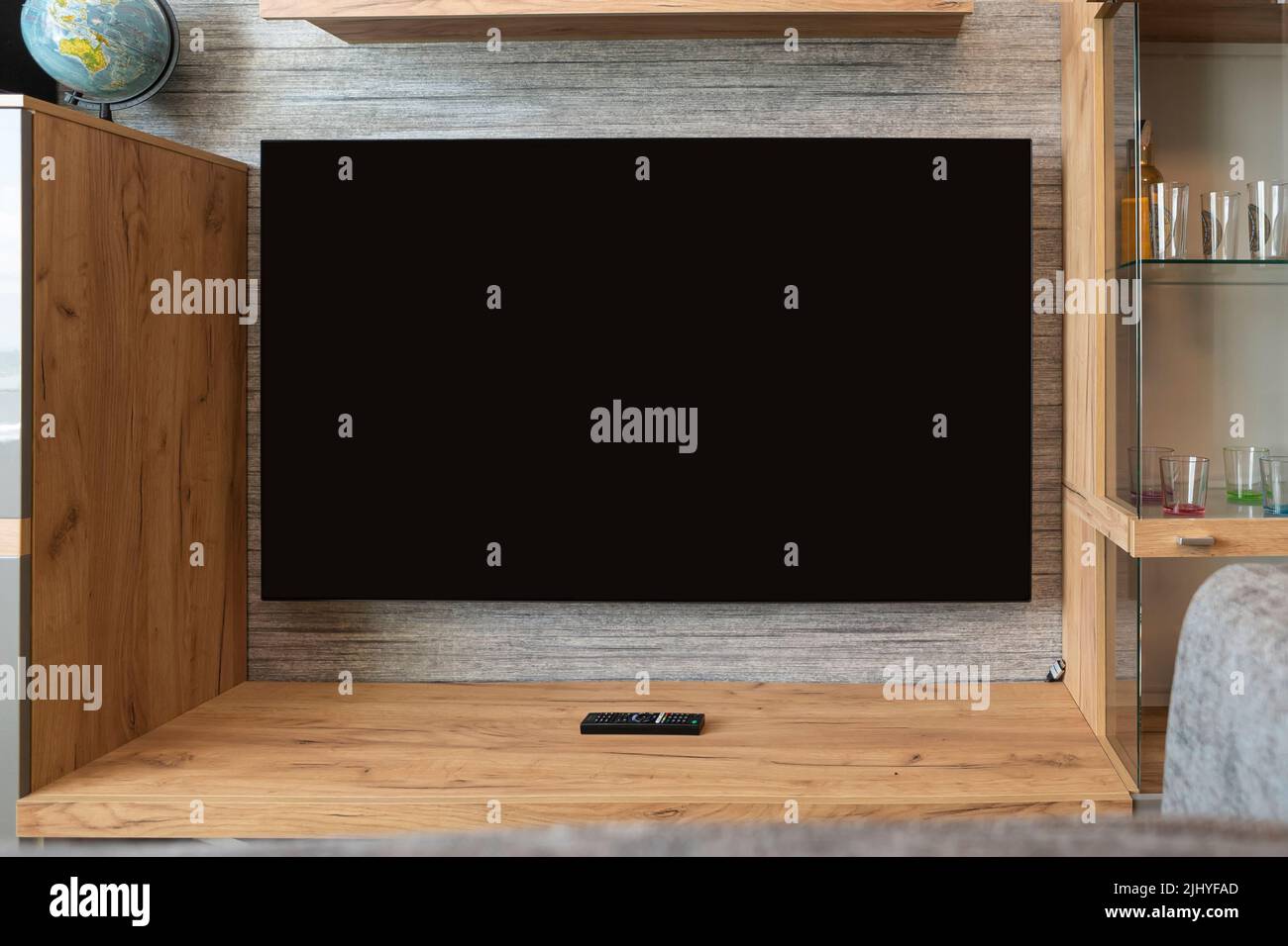 Moderner Fernseher auf dem Ständer im Wohnzimmer. Schwarzer Bildschirm für die Veröffentlichung von Informationen Stockfoto