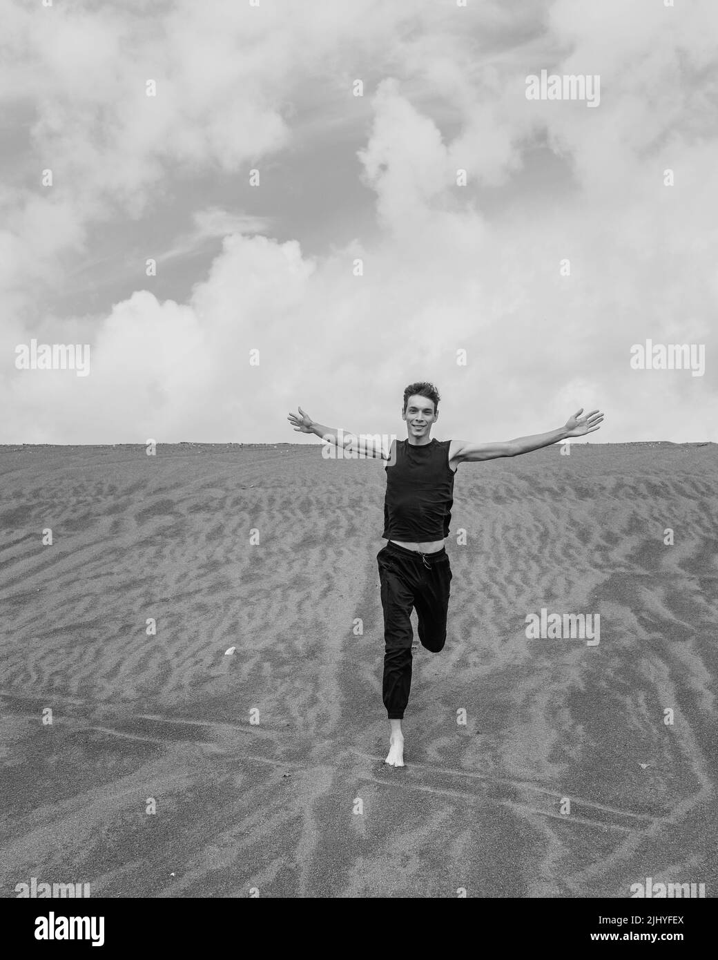 Einsame Mann, der auf dem Sand durch die sandige Wüste läuft Stockfoto