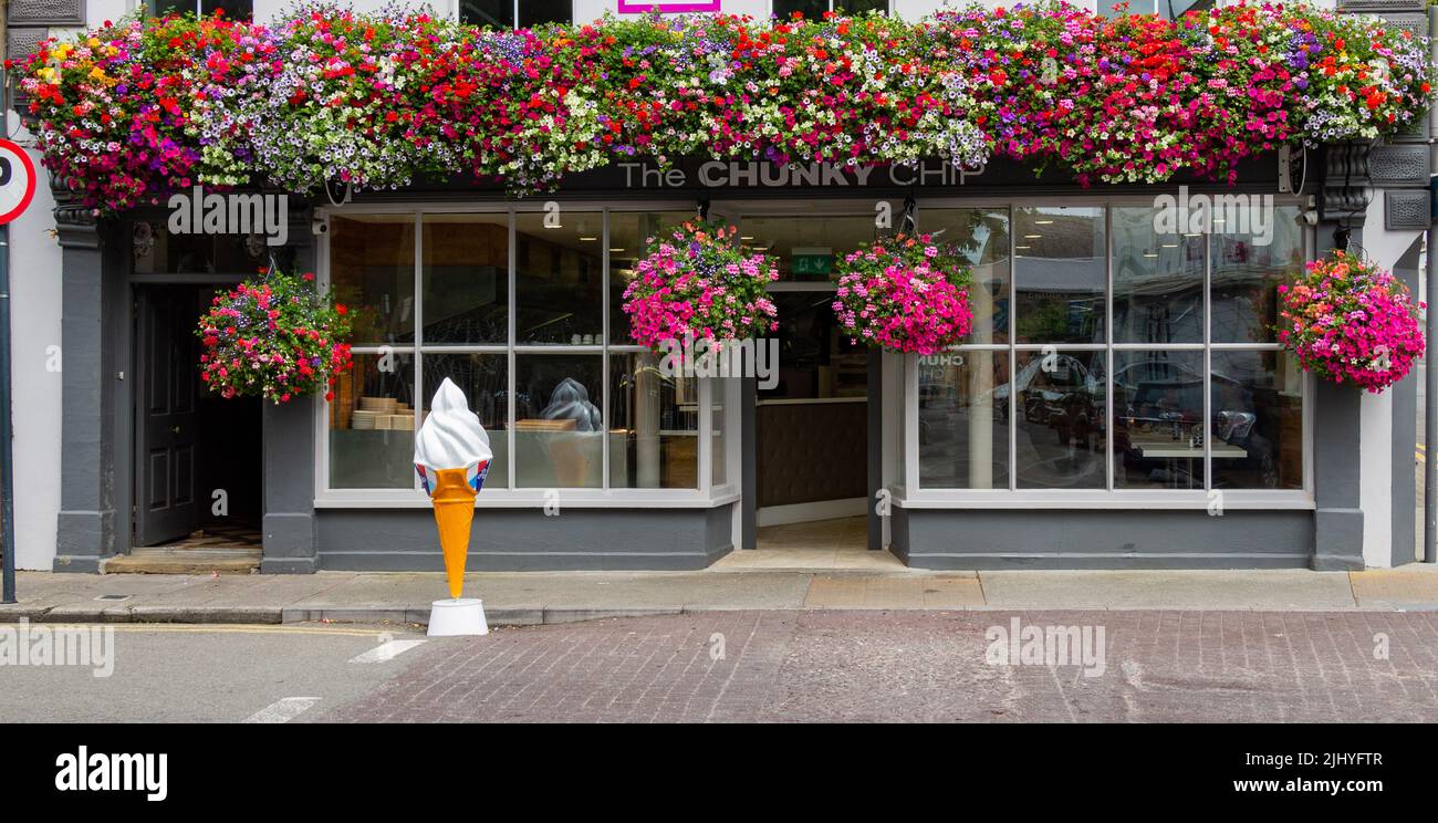 Im Sommer hängender Korb von Petunia über einer Ladenfront. Stockfoto