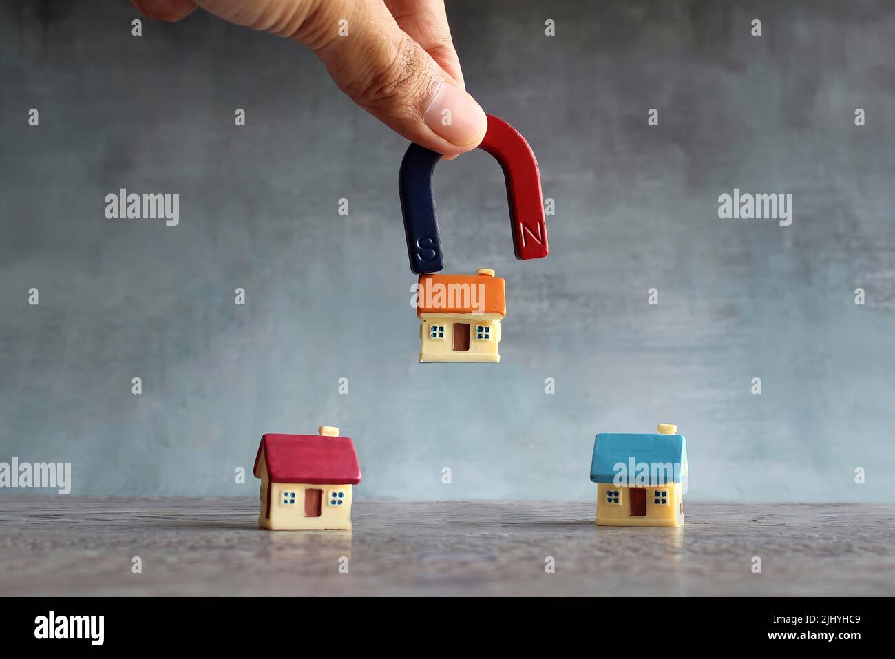 Magnet zieht Haus an. Ideales Haus, Traumhaus, Vergleich und wählte das richtige Hauskonzept. Stockfoto