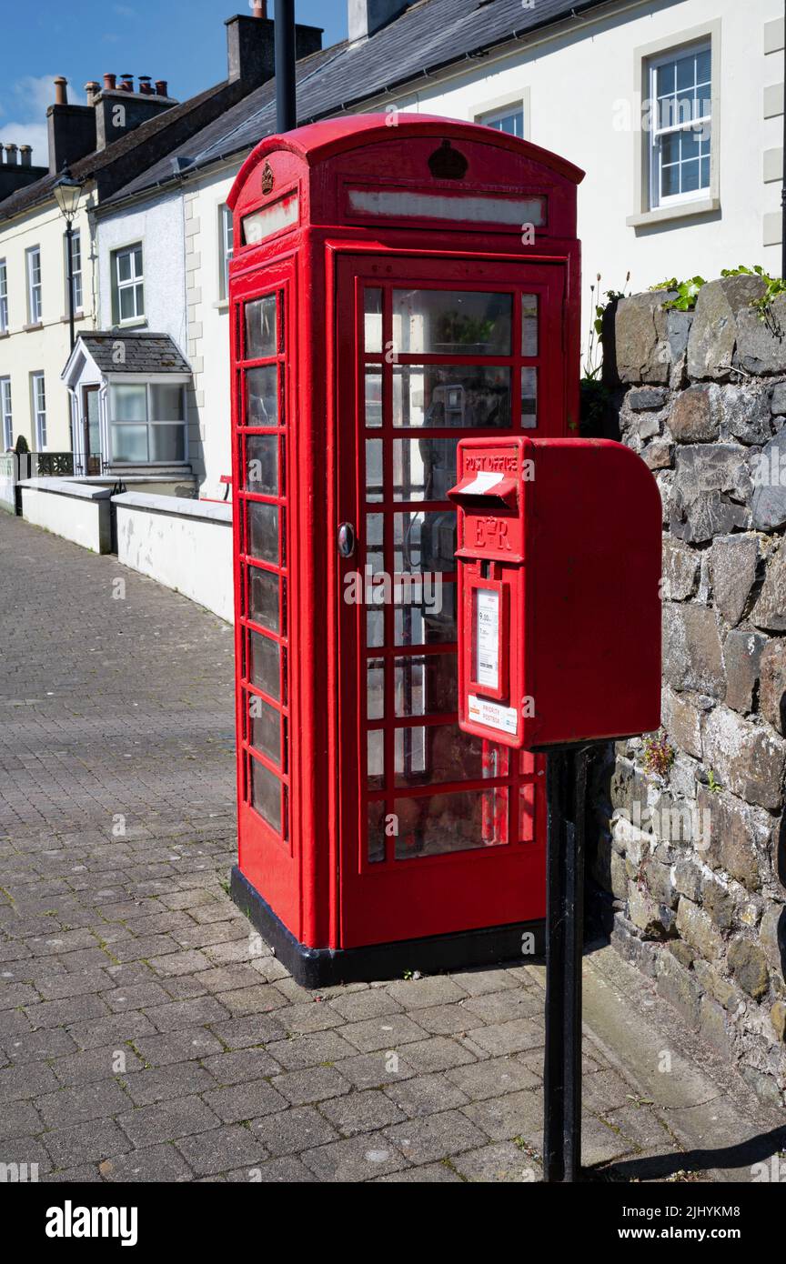 Glenarm, Großbritannien - 29. Mai 2022: Ein rotes britisches Telefon und eine Briefbox auf einer Straße in Glenarm Stockfoto
