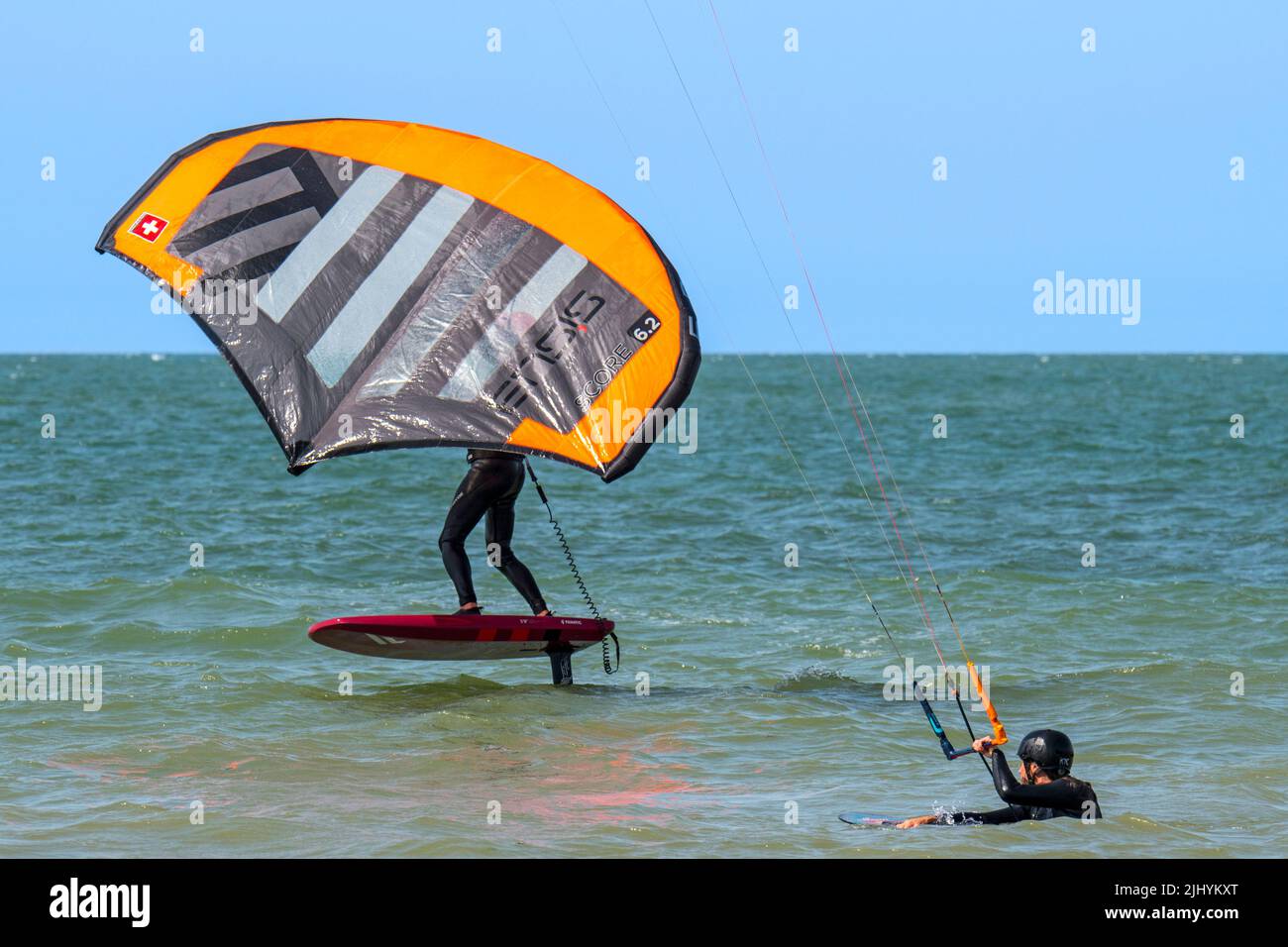Kiteboarder / Kitesurfer und Wingboarder / Wing Boarder auf Foilboard / Hydrofoil Board Surfen mit aufblasbarem Flügel an der Nordsee Stockfoto