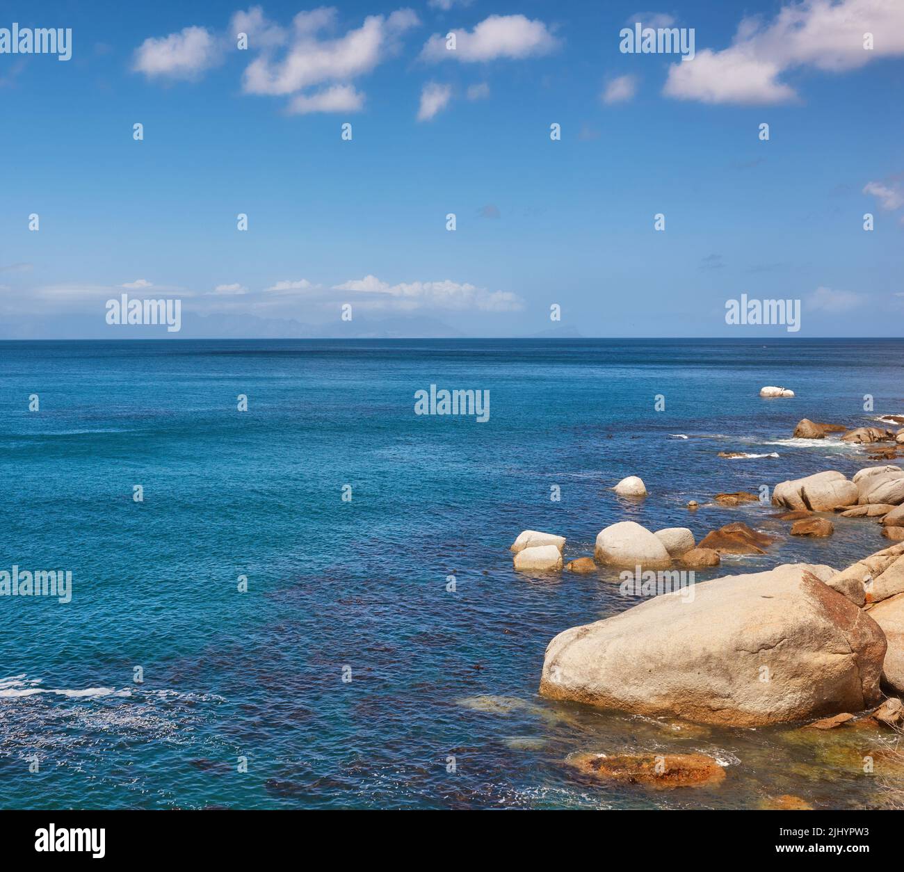 Die Landschaft eines tropischen Urlaubsziels. Schöner felsiger Strand mit einem wolkigen blauen Himmel Hintergrund an einem Sommertag mit Kopierfläche. Seascape Stockfoto