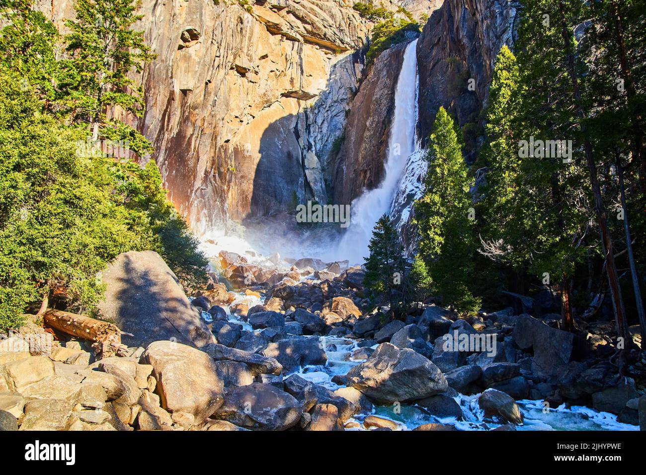 Yosemite Falls Anfang April mit frostigen Felsen und kleinem Regenbogen Stockfoto