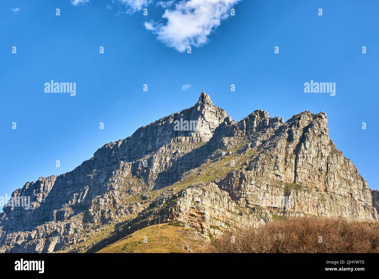 Wunderschöne Landschaft des Tafelbergs unten mit blauem Himmel und Kopierraum. Friedliche und malerische Aussicht auf einen Gipfel mit großen Felsen und Gras. Ein Gipfel in Stockfoto